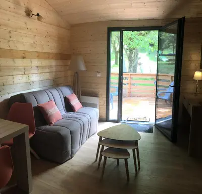 a living room with a couch and a table at Fanjeaux Aude Le Chalet in Fanjeaux