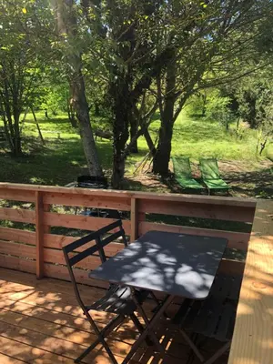 a table and chairs on a porch with a fence at Fanjeaux Aude Le Chalet in Fanjeaux