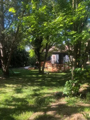 a house in the middle of a yard with trees at Fanjeaux Aude Le Chalet in Fanjeaux