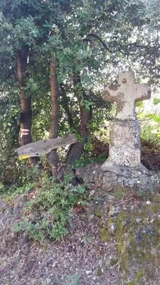 a stone cross sitting on top of a hill at La petite étape in Duilhac