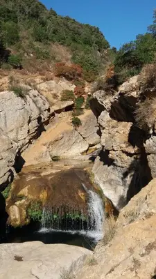 a waterfall on the side of a rocky mountain at La petite étape in Duilhac