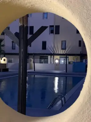 a view of a swimming pool at night at Les Drom's studio in Gruissan