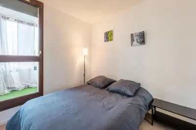 a bedroom with a bed and a large window at La Brigantine in Gruissan