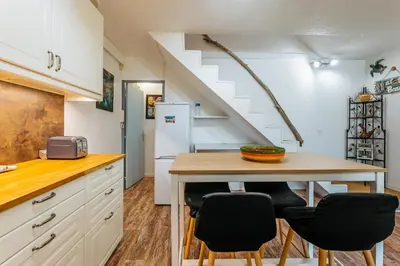 a kitchen with a table and chairs and a staircase at La Brigantine in Gruissan