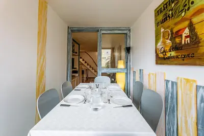 a dining room with a white table and chairs at La Brigantine in Gruissan