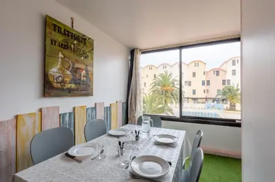 a dining room with a table and a large window at La Brigantine in Gruissan