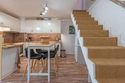 a kitchen with a staircase and a table and chairs at La Brigantine in Gruissan