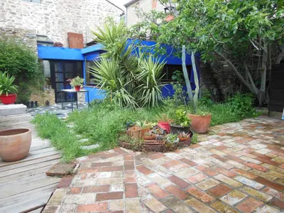 a garden with plants and a brick patio at maison dans jardin in Villesèque-des-Corbières