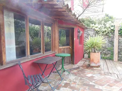 a small patio with a table and a green table at maison dans jardin in Villesèque-des-Corbières