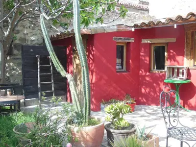 a red house with a cactus in the yard at maison dans jardin in Villesèque-des-Corbières