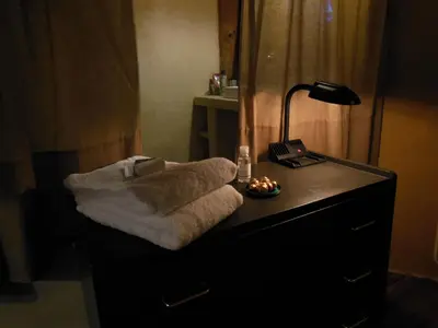 a pile of towels sitting on a dresser with a lamp at maison dans jardin in Villesèque-des-Corbières
