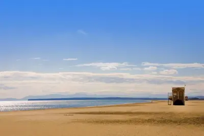 a beach with a lifeguard station on the sand at Mobil home 5-6 personnes - climatisé in Port-la-Nouvelle