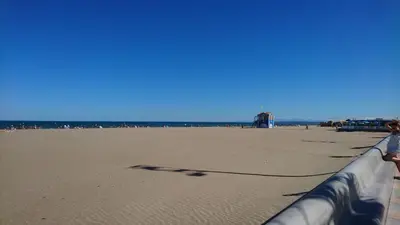 a view of a beach with people and the ocean at Mobil home 5-6 personnes - climatisé in Port-la-Nouvelle