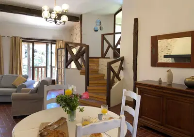 a living room with a table and a staircase at Gîtes de Montcabirol - Malepère in La Bastide-de-Bousignac