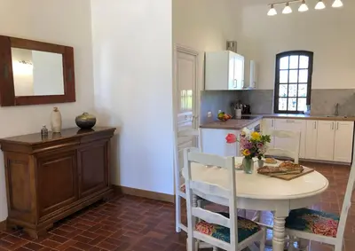 a kitchen with a table and a table and chairs at Gîtes de Montcabirol - Malepère in La Bastide-de-Bousignac