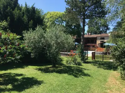 a yard with a fence and trees and a house at Gîtes de Montcabirol - Malepère in La Bastide-de-Bousignac