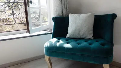 a blue chair with a pillow in a room with a window at Gîtes de Montcabirol - Malepère in La Bastide-de-Bousignac
