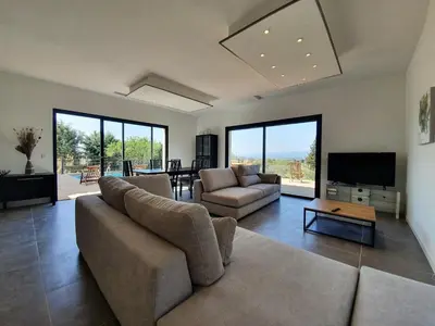 a large living room with a couch and a tv at Villa with Pool & Views in Oupia