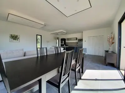 a dining room and living room with a black table and chairs at Villa with Pool & Views in Oupia