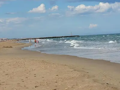 a group of people walking on the beach at Villa with Pool & Views in Oupia