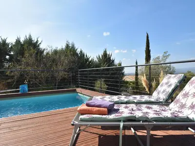 a pair of chairs sitting on a deck next to a swimming pool at Villa with Pool & Views in Oupia