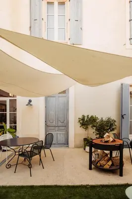 awning over a patio with two tables and chairs at La Maison de Gruissan in Gruissan
