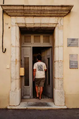 a man walking into a door of a building at La Maison de Gruissan in Gruissan