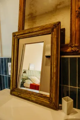 a mirror sitting on top of a counter in a bathroom at La Maison de Gruissan in Gruissan