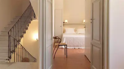 a bedroom with a bed and a stairway leading to a bedroom at La Maison de Gruissan in Gruissan