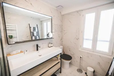a bathroom with a white sink and a mirror at La cathédrale à portée de main ! in Narbonne