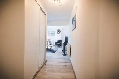 a hallway leading to a living room with a wooden floor at La cathédrale à portée de main ! in Narbonne