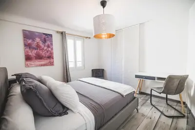 a bedroom with a bed and a desk in it at La cathédrale à portée de main ! in Narbonne