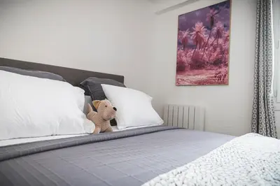 a stuffed teddy bear sitting on top of a bed at La cathédrale à portée de main ! in Narbonne