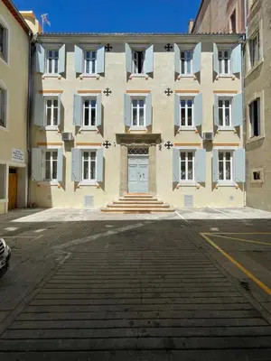a large building with a door in a street at Suite Royale Maison de l'église du couvent in Narbonne