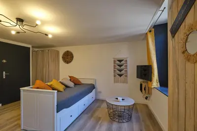 a bedroom with a bed and a table at Chez Juliette - Appart & Studios - Carcassonne centre in Carcassonne