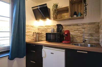 a kitchen with a sink and a microwave at Chez Juliette - Appart & Studios - Carcassonne centre in Carcassonne