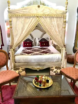 a bedroom with a canopy bed with a coffee table at Suite Orientale Maison de L'église du Couvent in Narbonne
