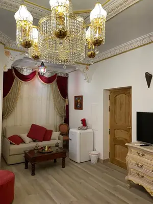 a living room with a couch and a chandelier at Suite Orientale Maison de L'église du Couvent in Narbonne