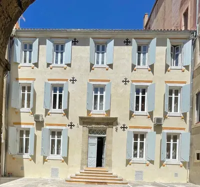 a building with blue and white windows and a door at Suite Orientale Maison de L'église du Couvent in Narbonne