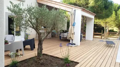 a wooden deck with a table and a tree at OXPIRA in Palaja
