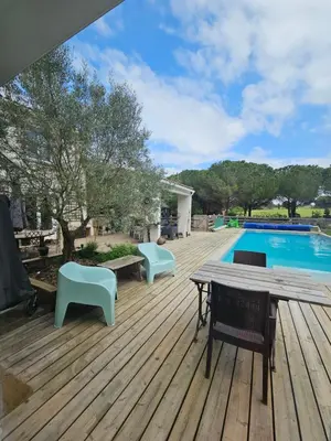a deck with a table and chairs next to a swimming pool at OXPIRA in Palaja