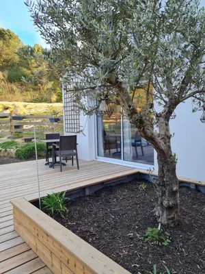 a wooden deck with a table and a tree at OXPIRA in Palaja