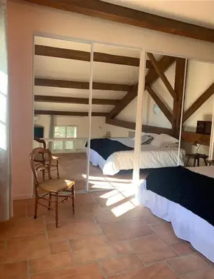 a bedroom with two beds and a chair in a room at Chambres d'hôtes la Soulenque Luxury B & B in Capestang