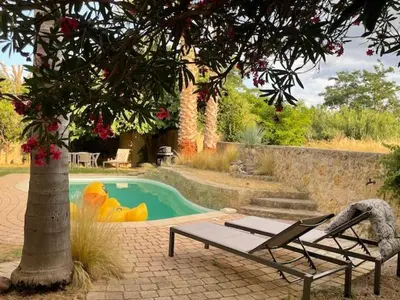 a pool with a table and a chair next to a tree at Chambres d'hôtes la Soulenque Luxury B & B in Capestang