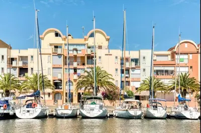 a group of boats docked in front of a building at Résidence Port Soleil Duplex T3 46 m2 climatisé in Gruissan