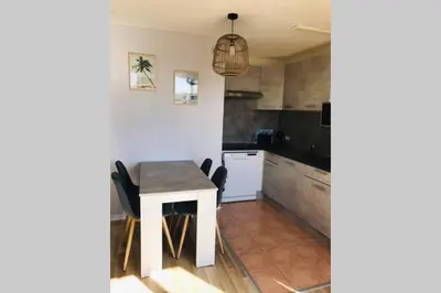 a kitchen with a table and chairs in a room at Résidence Port Soleil Duplex T3 46 m2 climatisé in Gruissan
