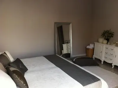 a bedroom with a large bed and a mirror at Villa Zen in Narbonne