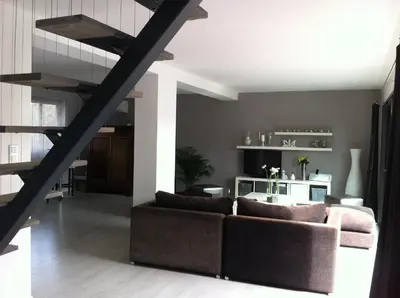 a living room with a couch and a staircase at Villa Zen in Narbonne