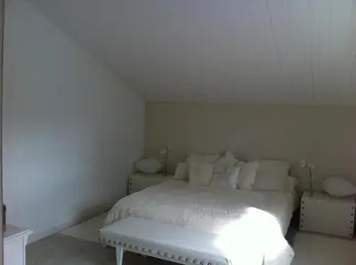a bedroom with a white bed and a bench at Villa Zen in Narbonne