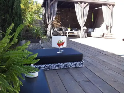 a table with a wine glass on it on a deck at Villa Zen in Narbonne